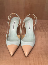 Pair of light blue Manolo Blahniks and beige pointed-toe shoes on a wooden surface