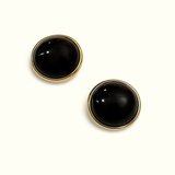 Pair of black onyx round earrings with gold rims on a white background