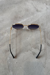 Sunglasses with gold frame and dark lenses